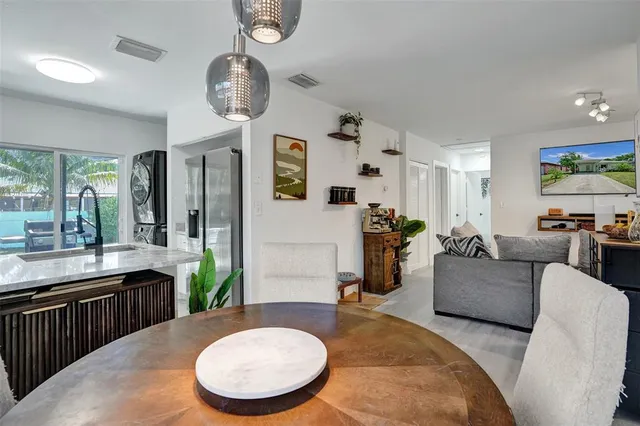 a living room with furniture a large window and kitchen view