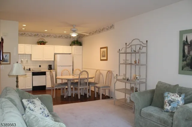 a living room with furniture kitchen view and a large window
