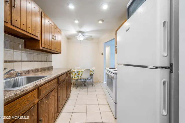 a kitchen with a sink refrigerator and cabinets