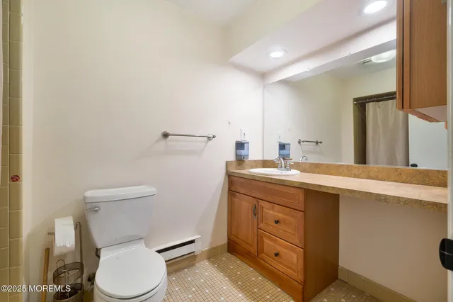 a bathroom with a toilet a sink and mirror
