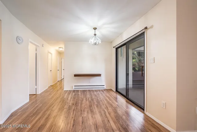a view of a room with wooden floor a ceiling fan and windows