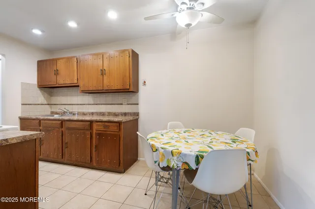 a kitchen with kitchen island granite countertop a sink cabinets and wooden floor