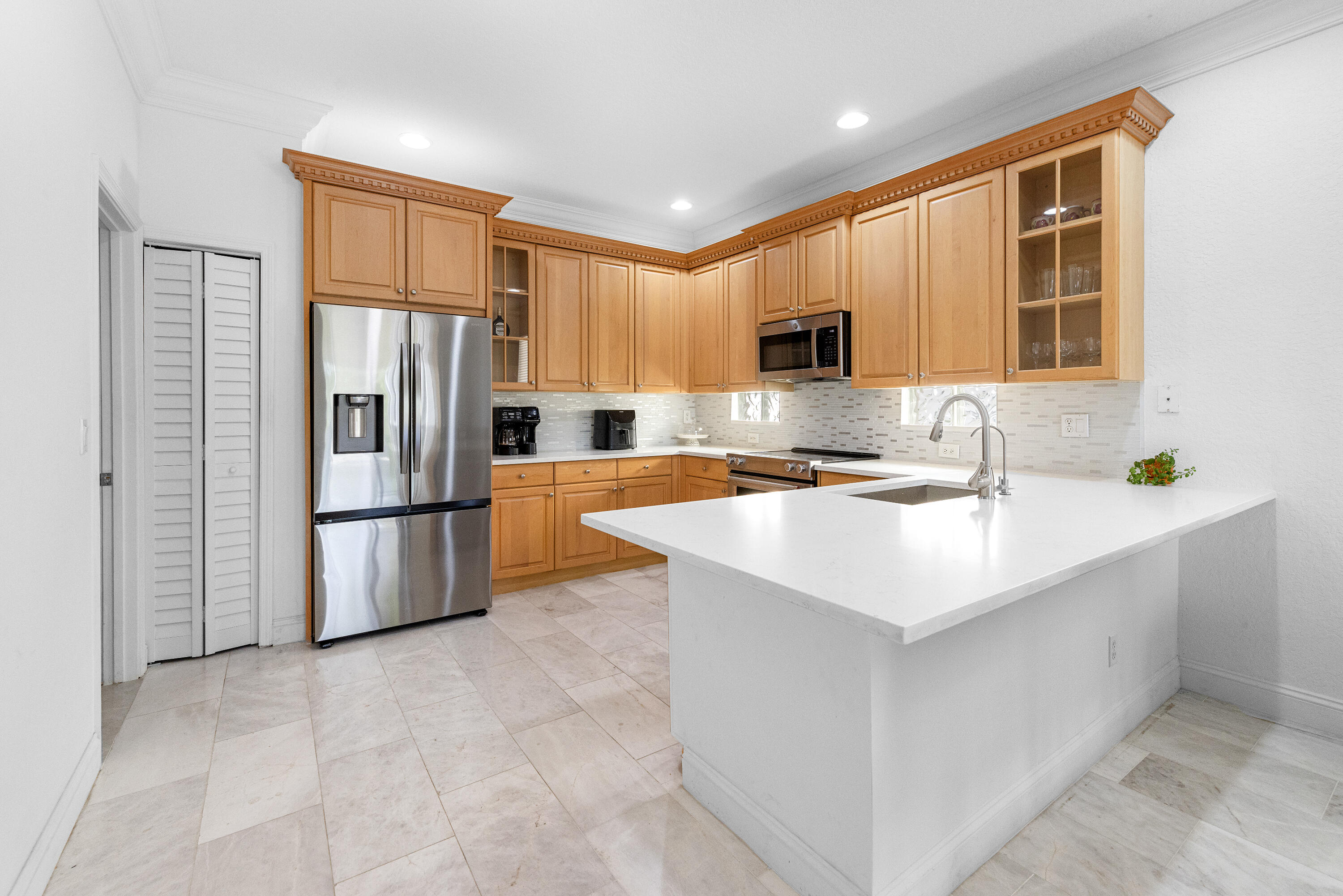 6575 Spring Meadow Drive Greenacres, FL 33413 - Photo 12 of 51 a kitchen with stainless steel appliances a refrigerator sink and microwave