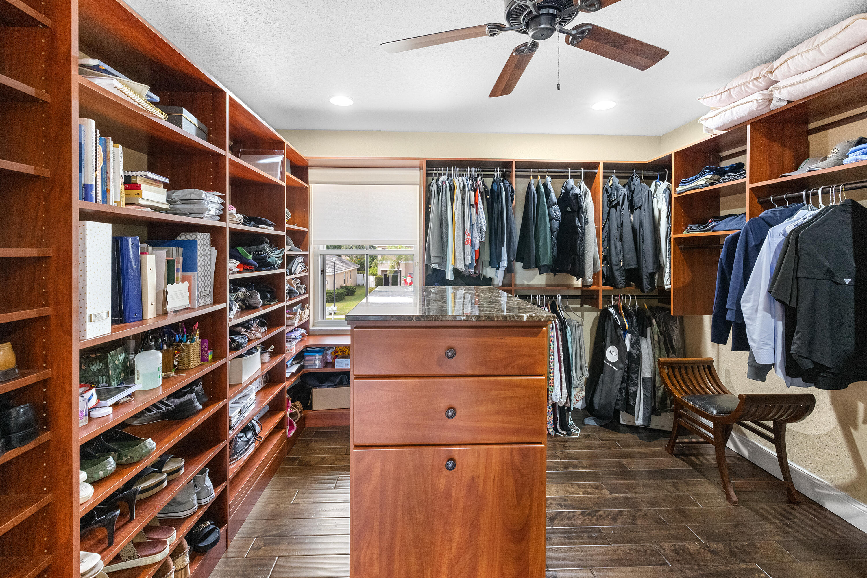 6575 Spring Meadow Drive Greenacres, FL 33413 - Photo 21 of 51 a view of walk in closet with clothes and shoes