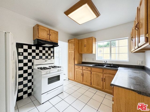 a bathroom with a granite countertop sink a toilet and a shower