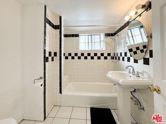 a bathroom with a sink a mirror and a bathtub