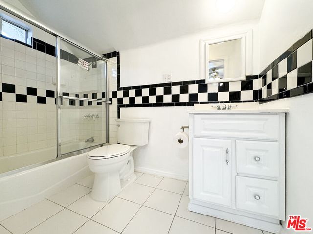a view of a big room with a chandelier fan and windows