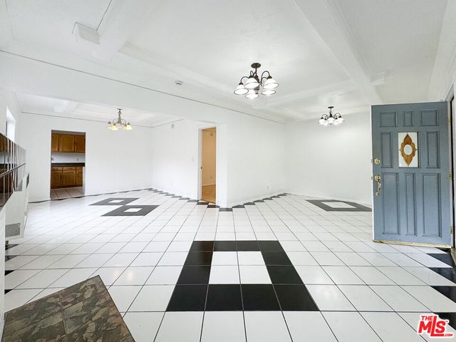 a view of a livingroom with wooden floor and kitchen space