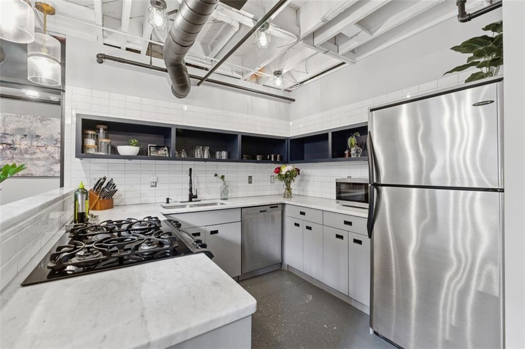830 DeKalb Avenue Northeast, Unit 11 Atlanta, GA 30307 - Photo 12 of 37 a kitchen with stainless steel appliances granite countertop a refrigerator a sink dishwasher a stove and a refrigerator with wooden floor