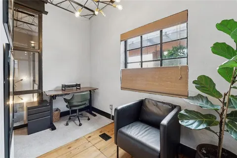 a living room with furniture and a painting on the wall