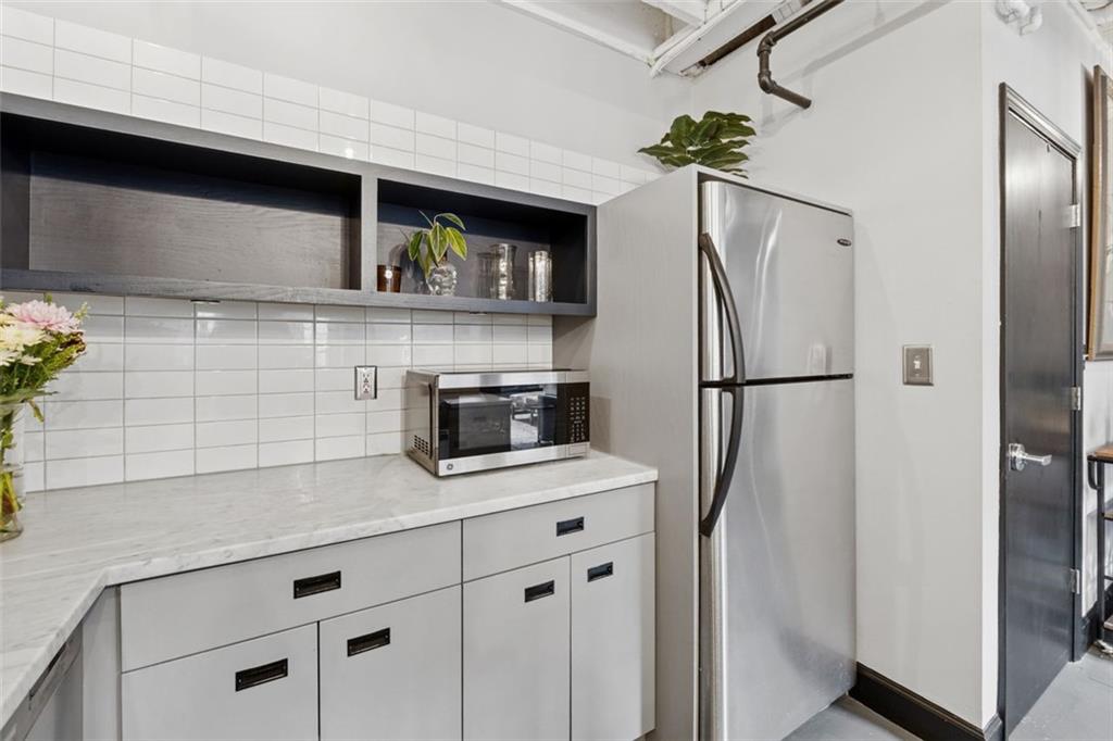 830 DeKalb Avenue Northeast, Unit 11 Atlanta, GA 30307 - Photo 31 of 37 a kitchen with stainless steel appliances granite countertop a refrigerator and a counter