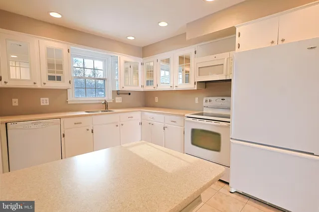 a kitchen with granite countertop white cabinets and white appliances