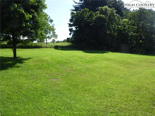 a view of a field of grass and trees