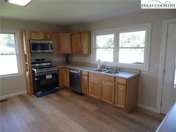a kitchen with granite countertop a stove top oven sink and cabinets