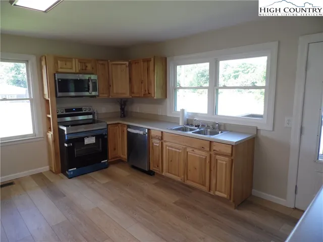 a kitchen with granite countertop a stove top oven sink and cabinets