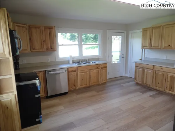 a large kitchen with stainless steel appliances granite countertop a sink a stove refrigerator and cabinets