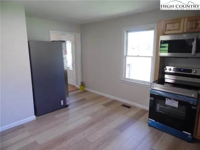 a view of kitchen and hallway with wooden floor