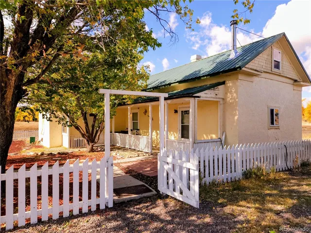 a view of a house with a small yard and wooden fence