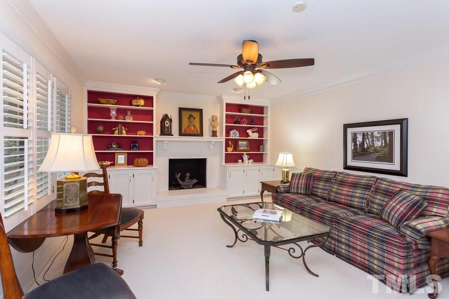 8609 Seagate Drive Raleigh, NC 27615 - Photo 7 of 28 Can't you just see the Christmas tree in this room with fireplace and gorgeous bookshelves. Door leads to screened porch.