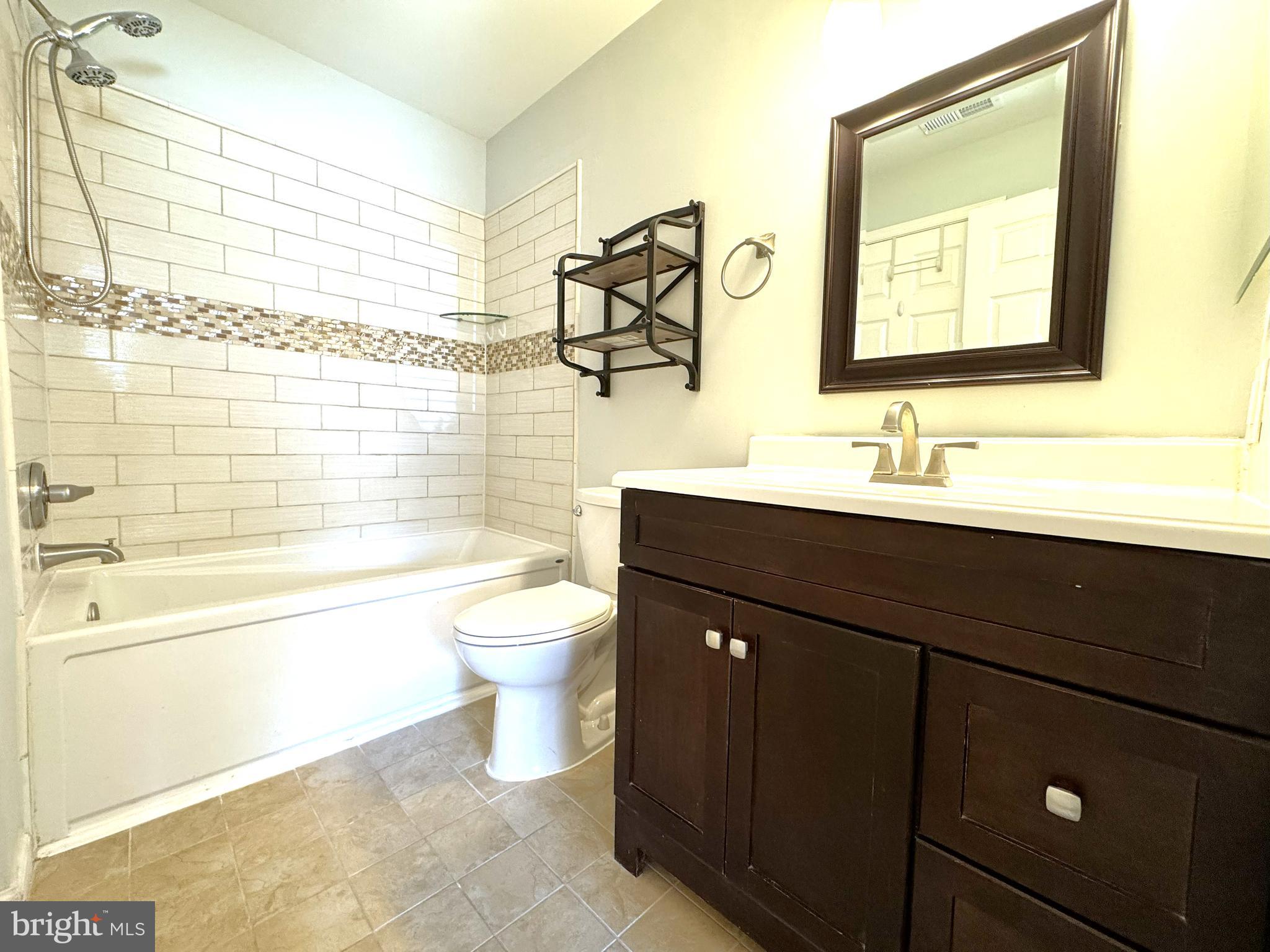 12012 Golf Ridge Court, Unit 102 Fairfax, VA 22033 - Photo 12 of 26 a bathroom with a double vanity sink toilet and shower
