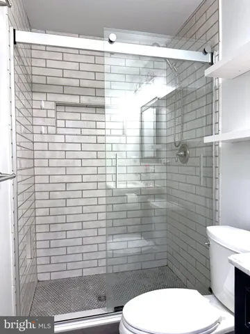 a bathroom with a toilet and a shower