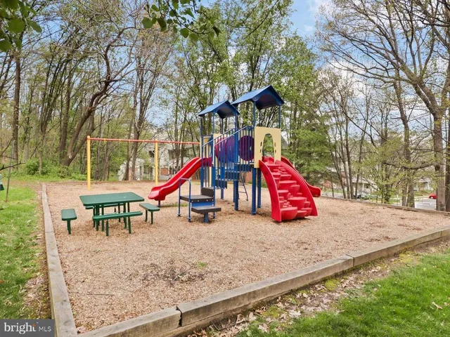a park with slide and a bench