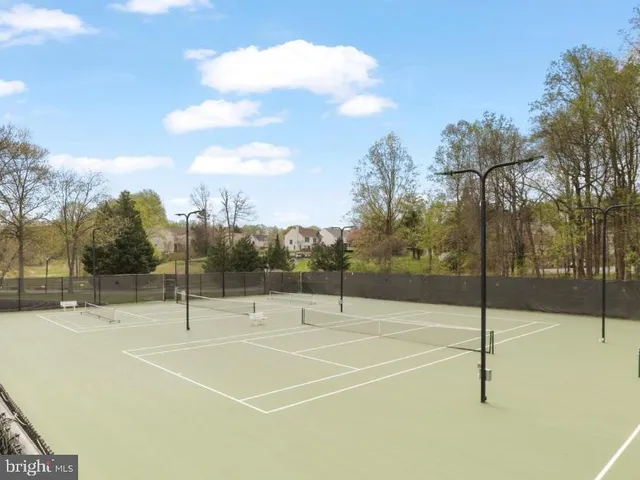 a view of a tennis court with trees in the background