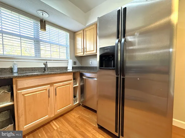 a kitchen with stainless steel appliances granite countertop a refrigerator and a sink