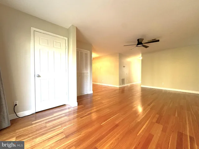 a view of a room with wooden floor and a ceiling fan