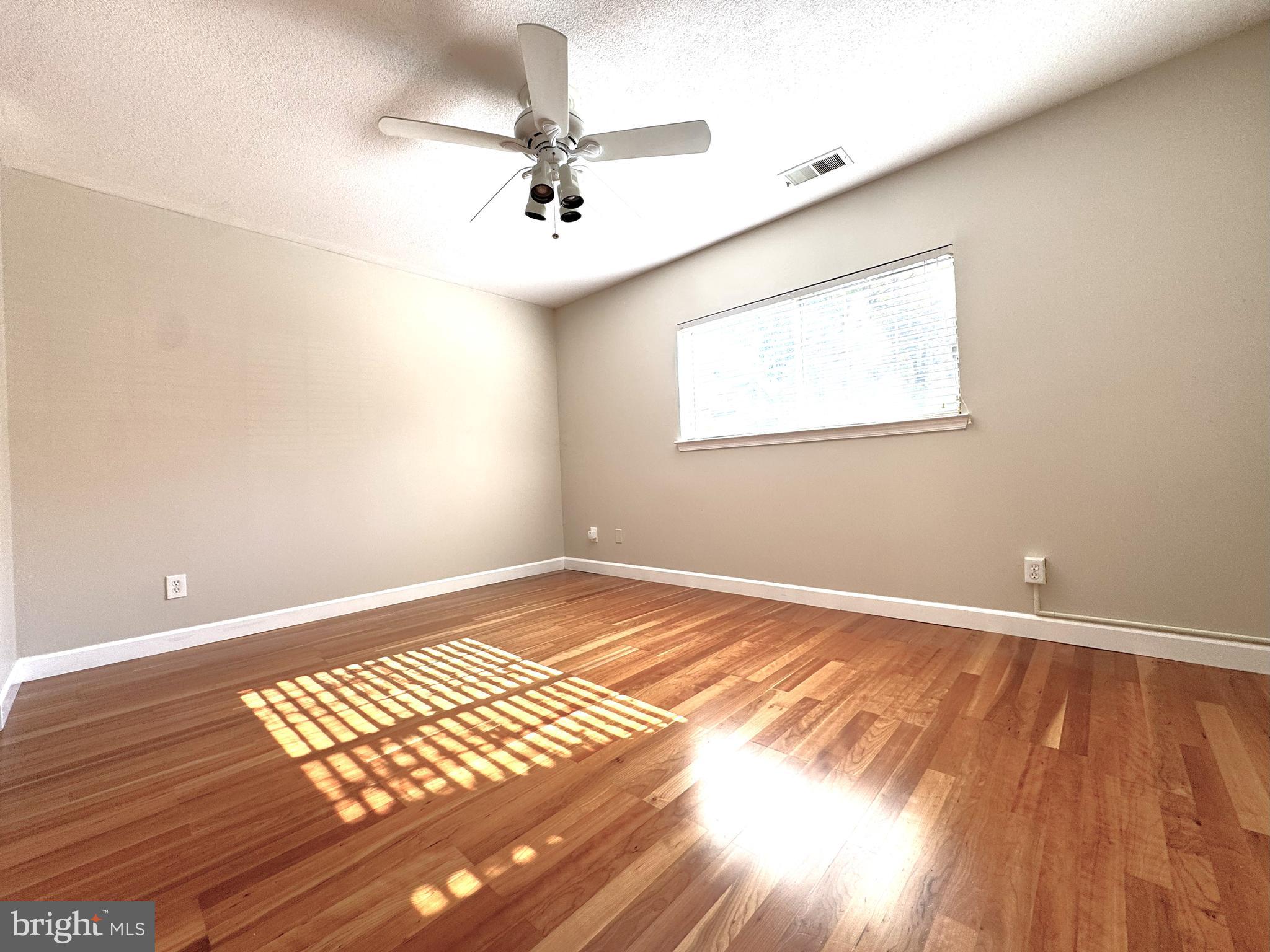 12012 Golf Ridge Court, Unit 102 Fairfax, VA 22033 - Photo 10 of 26 a view of an empty room with wooden floor and a window