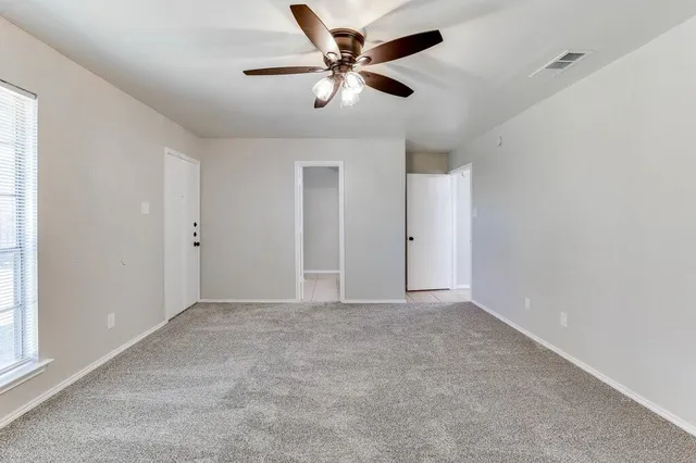 an empty room with closet and windows