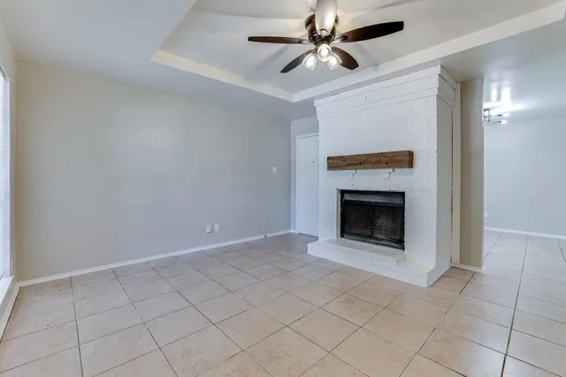 an empty room with windows and fireplace