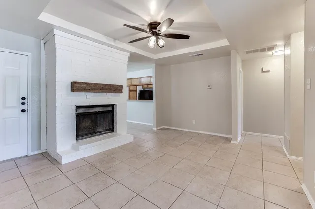 an empty room with fireplace and fan