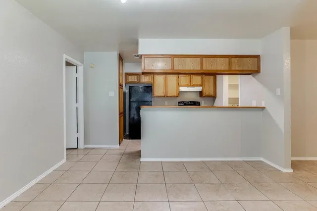 a view of a kitchen with a sink and a refrigerator