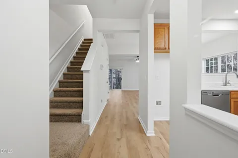 a view of a hallway with wooden floor and staircase