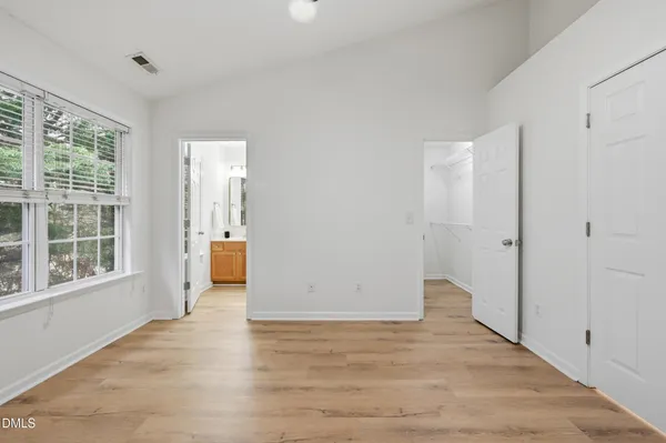 a view of a big room with wooden floor and windows