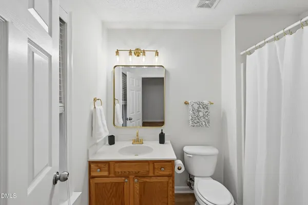 a bathroom with a granite countertop toilet sink and mirror