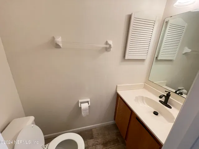 a bathroom with a sink mirror and toilet
