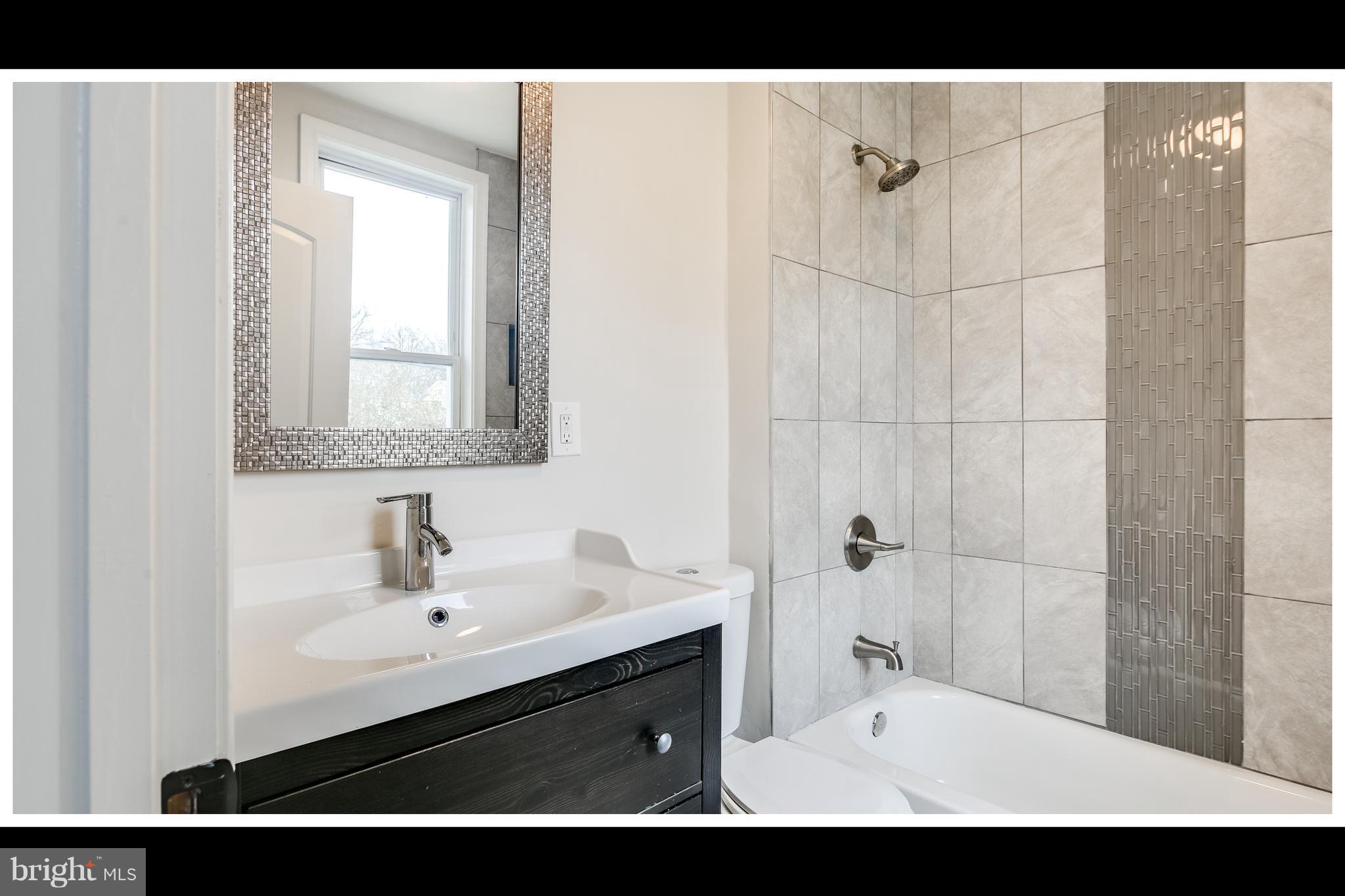 2900 Allendale Road Baltimore, MD 21216 - Photo 11 of 29 a bathroom with a sink a mirror and a shower
