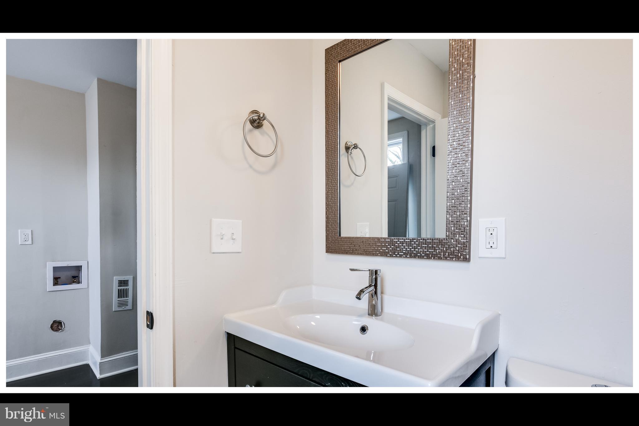 2900 Allendale Road Baltimore, MD 21216 - Photo 12 of 29 a view of a bathroom with a sink and mirror