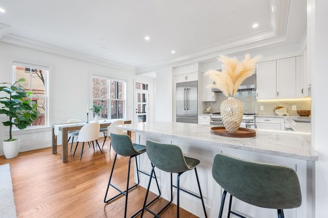 a living room with furniture a dining table and a potted plant