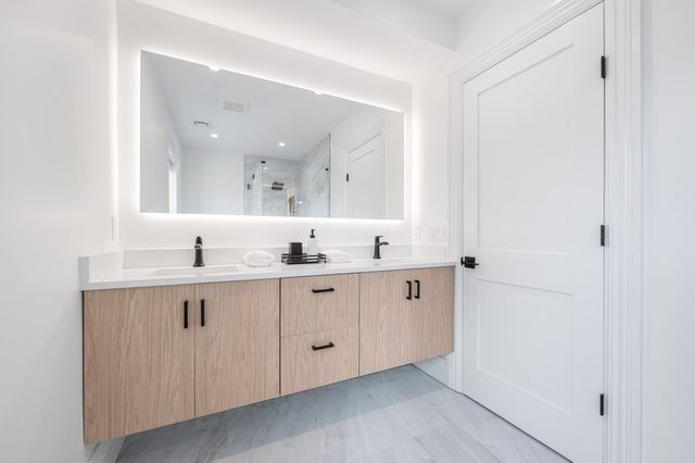 a bathroom with a double vanity sink and mirror