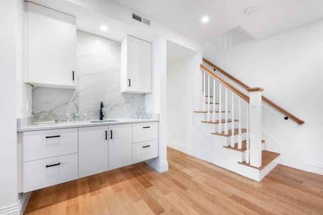 a hallway with white cabinets and window