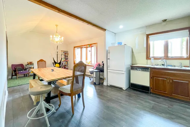 a kitchen with a table chairs refrigerator and cabinets