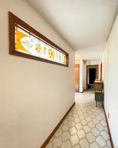 a view of a hallway to a room with a window