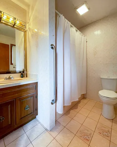 a spacious bathroom with a double vanity sink toilet and a mirror