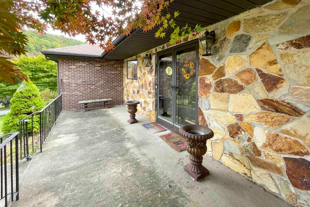 a front view of a house with a garden and trees