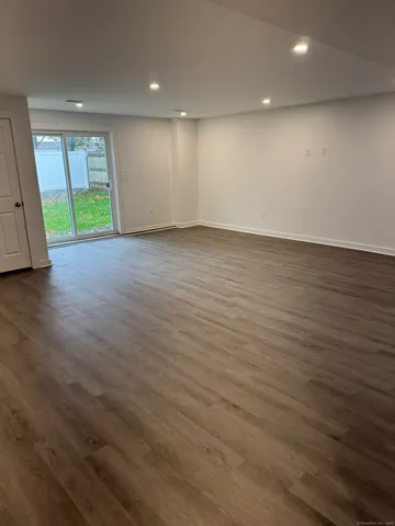 an empty room with wooden floor and a window