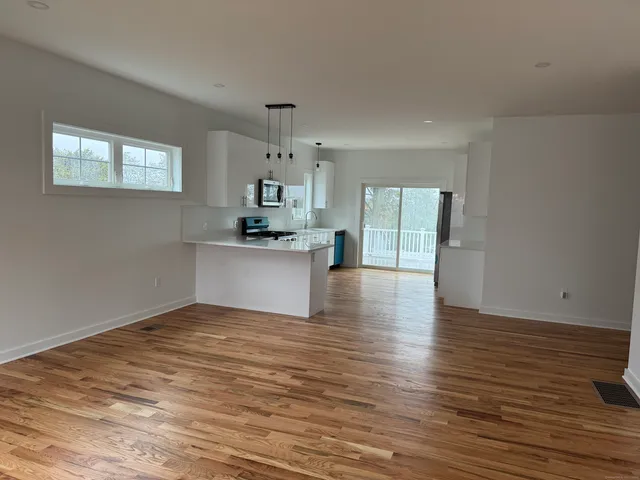 a view of a kitchen with wooden floor and a window