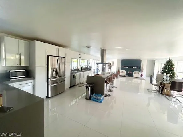 a kitchen with refrigerator and chairs